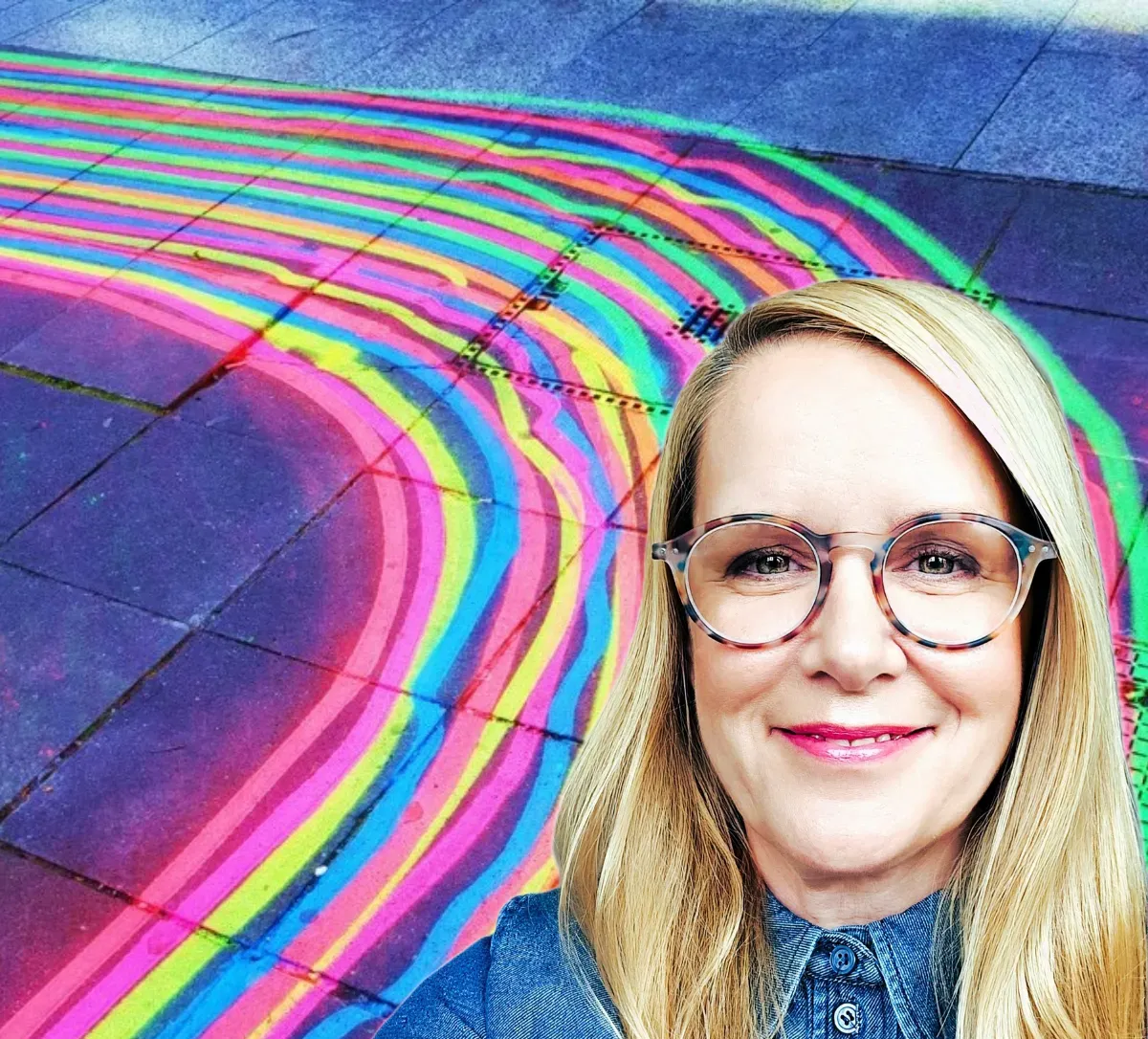 Christiane Warmuth vor regenbogenfarbenen Linien auf Straßenpflaster